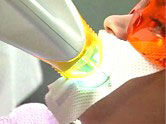 Photo of gel light activation step during a patient's teeth whitening treatment.